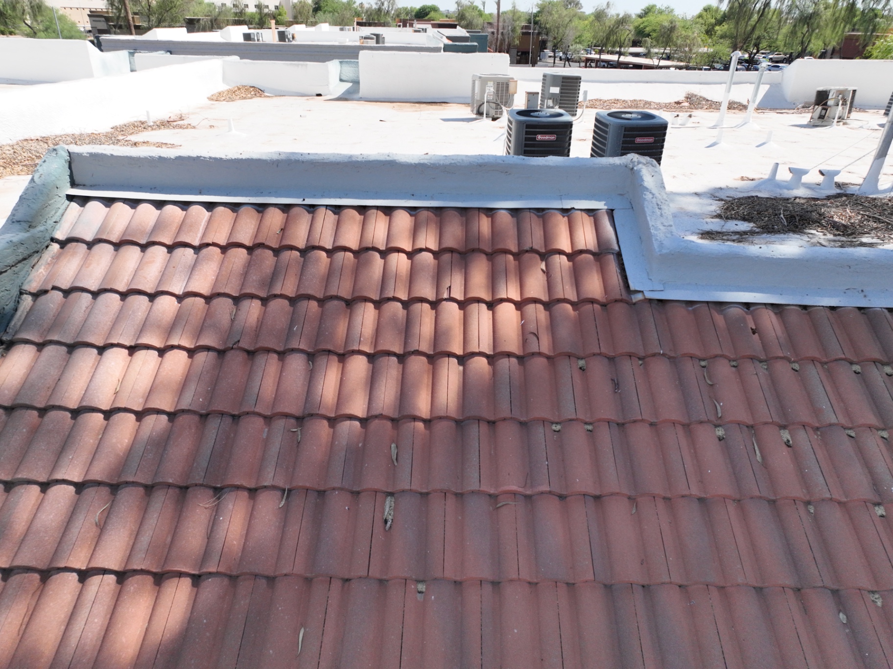 Red concrete S-tile mansard trim on Chandler AZ apartment building next to spray foam roof