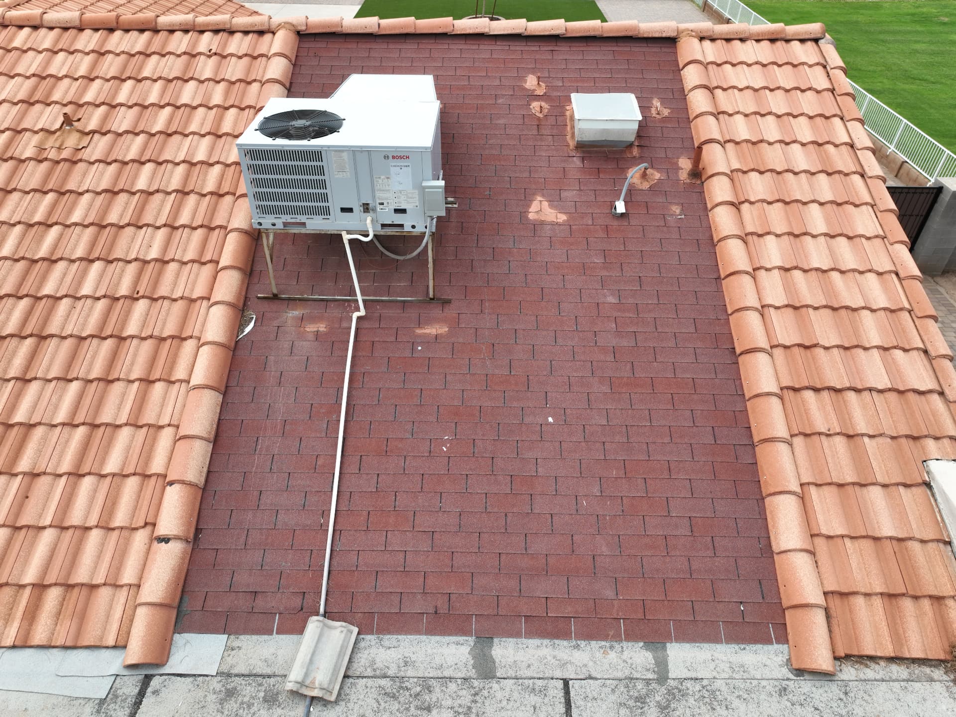 Top-mounted HVAC unit on a low-slope roof section surrounded by tile in Chandler AZ