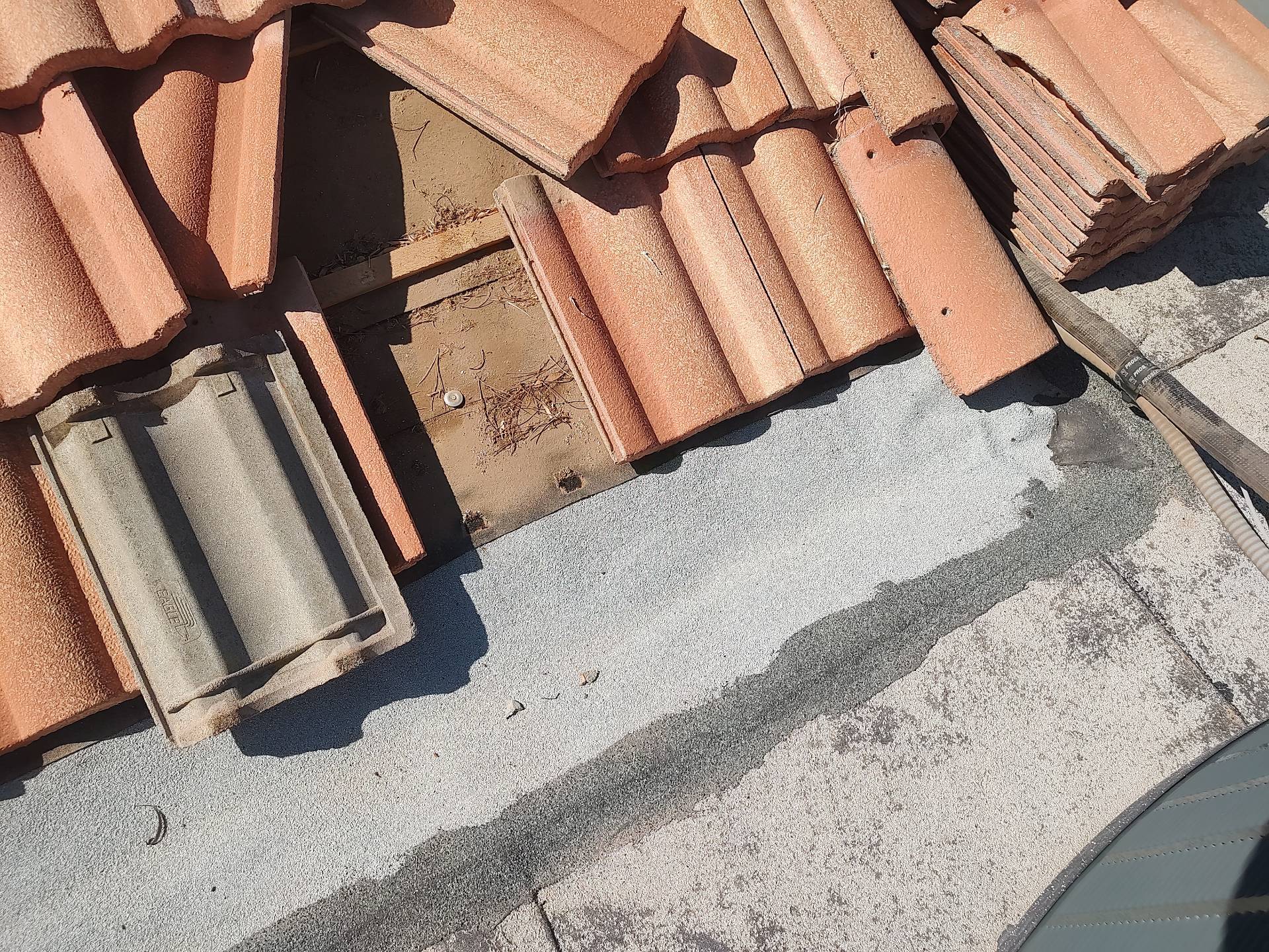 Lifted concrete tile exposing the roof deck and old underlayment in Chandler AZ