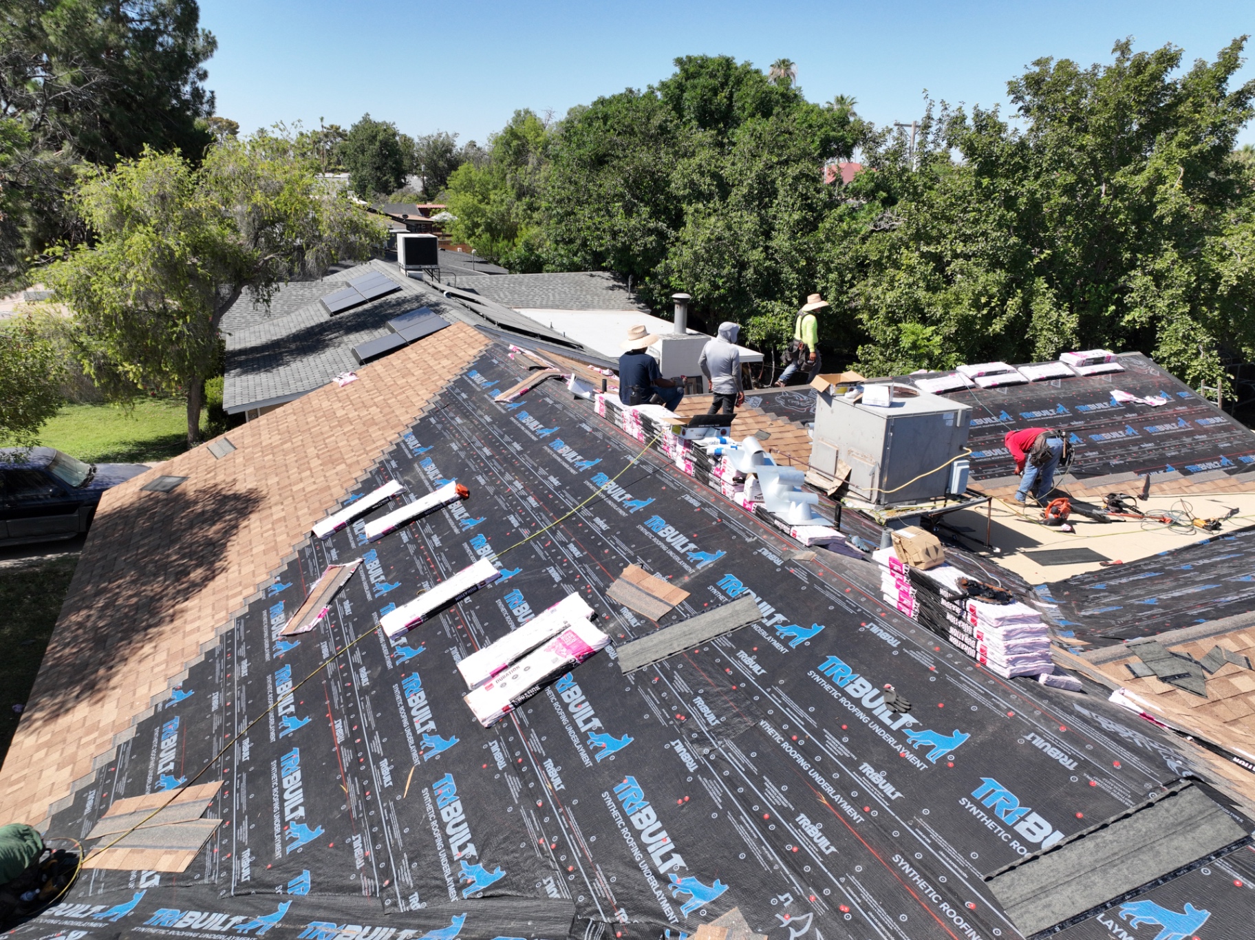 Mesa roof replacement in progress with synthetic underlayment installed across shingle slopes