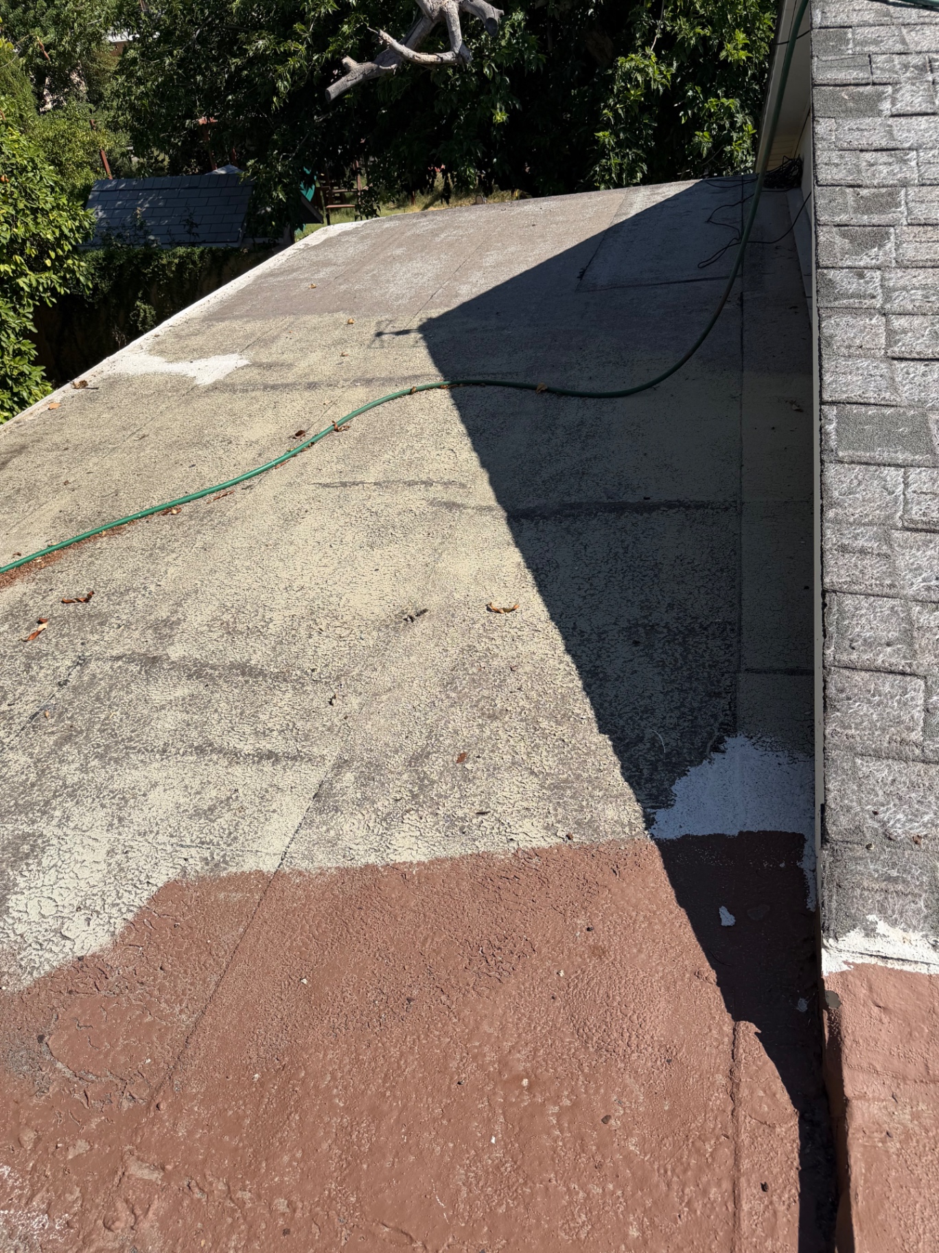 Failed elastomeric coating layers peeling and cracking on flat roof section