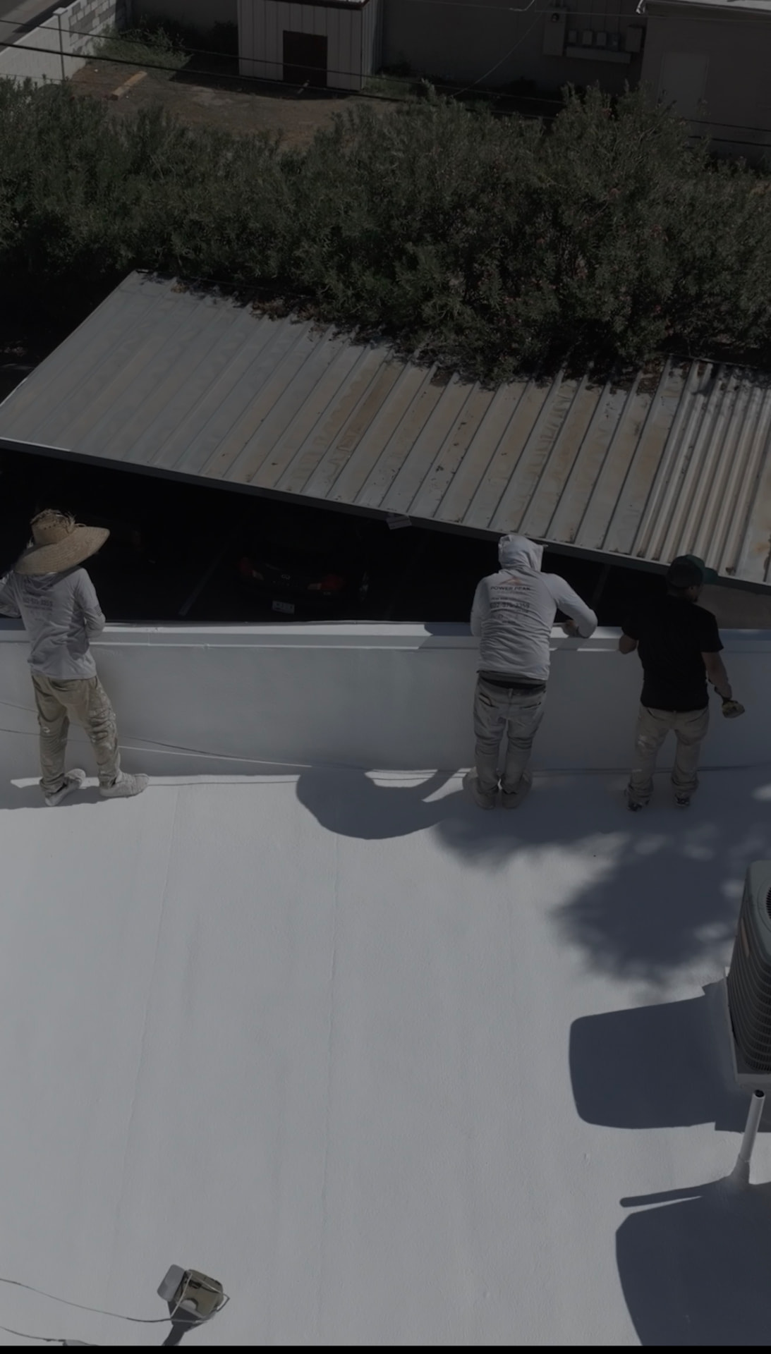 Power Peak Roofing crew coating a parapet wall on a Scottsdale AZ condominium roof