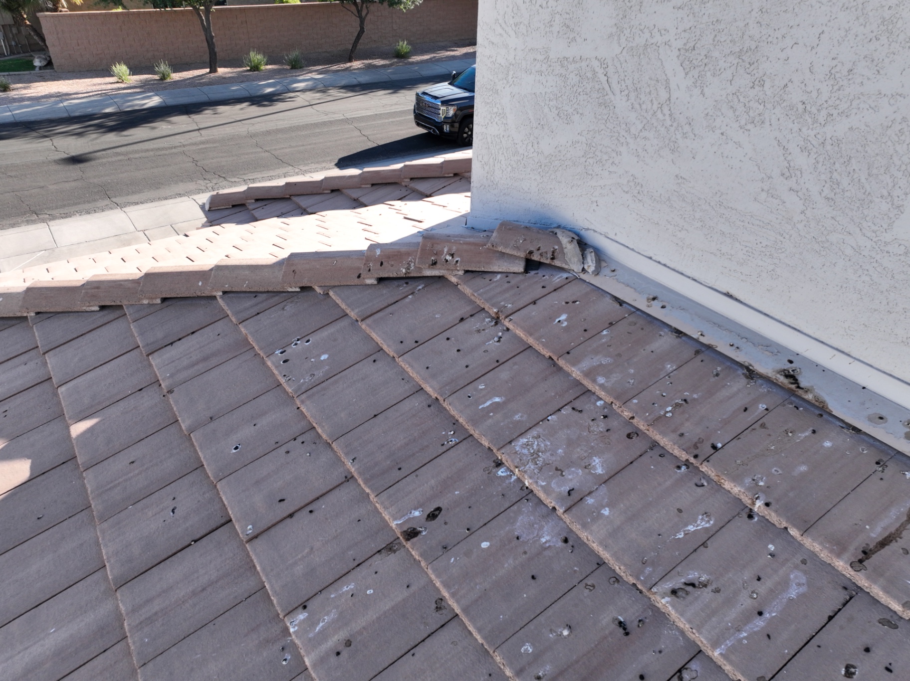 Broken rake tiles and spalling along gable