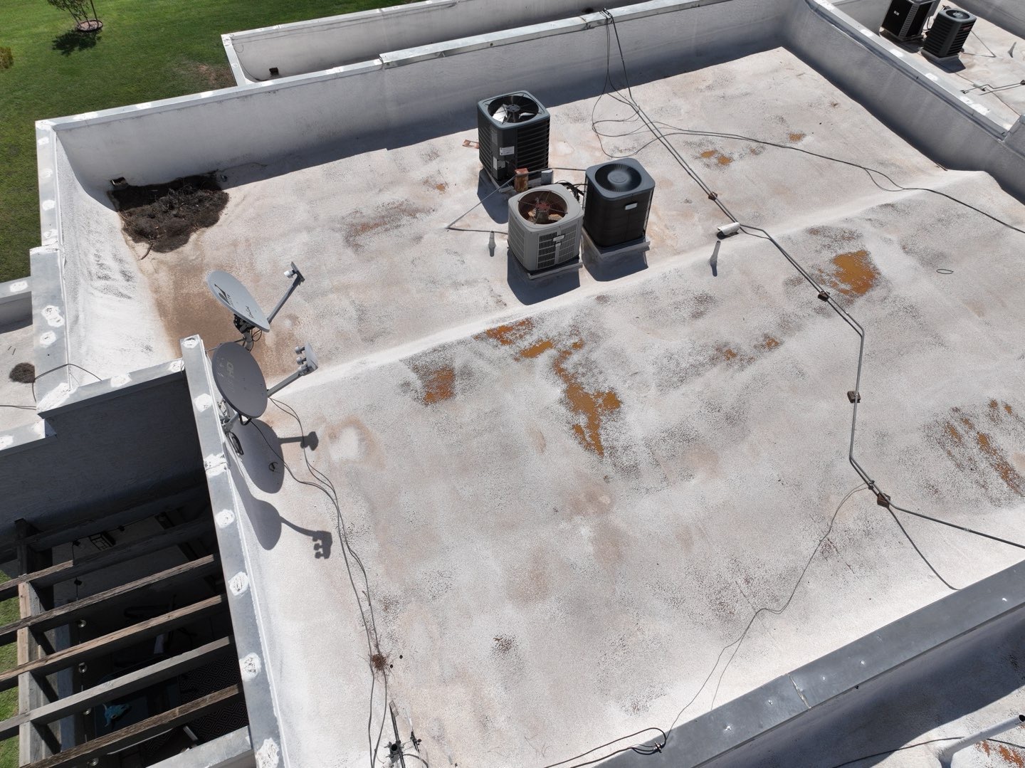 Weathered low-slope condominium roof with staining and rooftop HVAC units in Scottsdale AZ 85251 before recoating