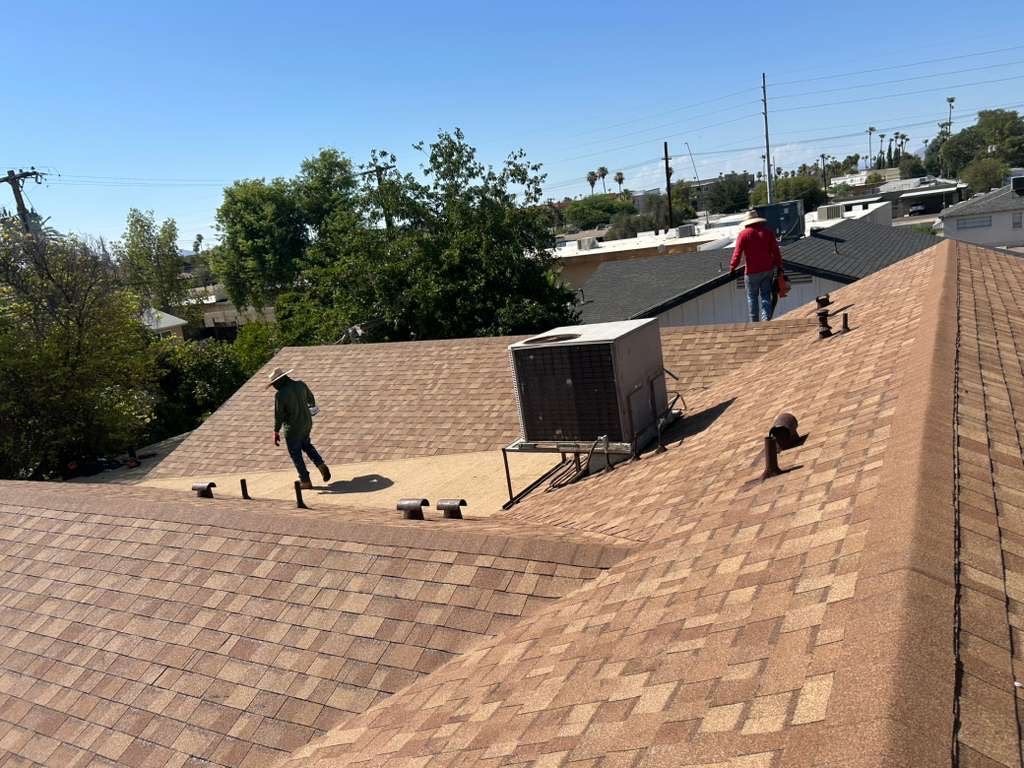 Completed Mesa shingle and low-slope roof replacement with crew doing final cleanup