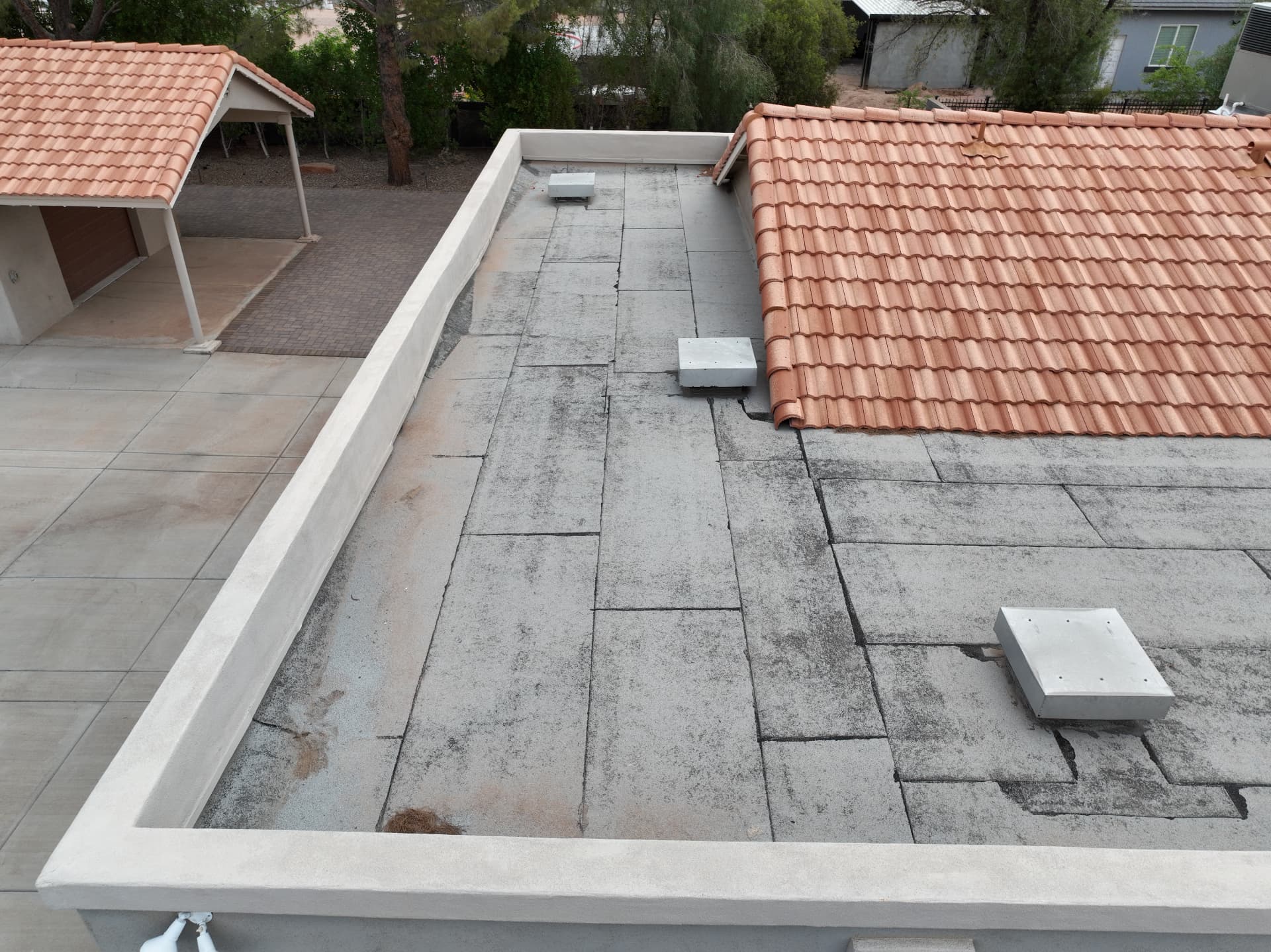 Weathered rolled roofing section with parapet walls on a Chandler AZ county island home